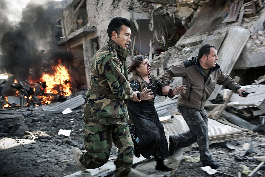 An Afghan women is rushed by Afghan security forces from the scene of a suicide car bomb in Kabul, Afghanistan on Dec. 15, 2009. Afghan authorities reported that eight people were killed and 40 were wounded. | commons.wikimedia.org | N Veenstra