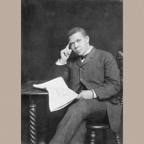 Booker T. Washington, three-quarter length portrait, seated, facing slightly left, holding newspaper | Library of Congress Prints and Photographs Division Washington, D.C. 20540 USA | Date Created/Published: between 1890 and 1900