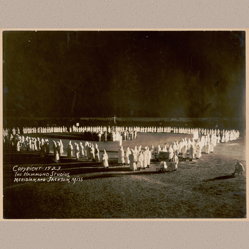 1923 Aug. 13 - Photograph shows a large gathering of Ku Klux Klan members encircling a group of new members taking part in an initiation at night. | Library of Congress Prints and Photographs Division Washington, D.C. 20540 USA | The Hammond Studios, Meridian and Jackson, Miss. | Date Created/Published: 9 June 1956