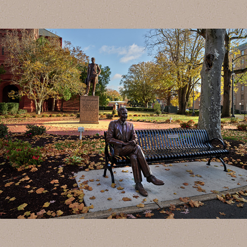 Statues of two figures from a different era on the campus of Hampton University, a historically black university in Hampton, Virginia. Seated is a figure of former U.S. president George H.W. Bush, who, during his presidency (1989-93), supported HBCUs (historically black colleges and universities), many of which were struggling. The figure behind the seated Bush is Samuel Chapman Armstrong, also a white man, the son of missionaries to Hawaii, who commanded Union African-American troops during the American Civil War of the 1860s. | Library of Congress Prints and Photographs Division Washington, D.C. 20540 USA | Highsmith, Carol M., photographer | Date Created/Published: 2019-11-24
